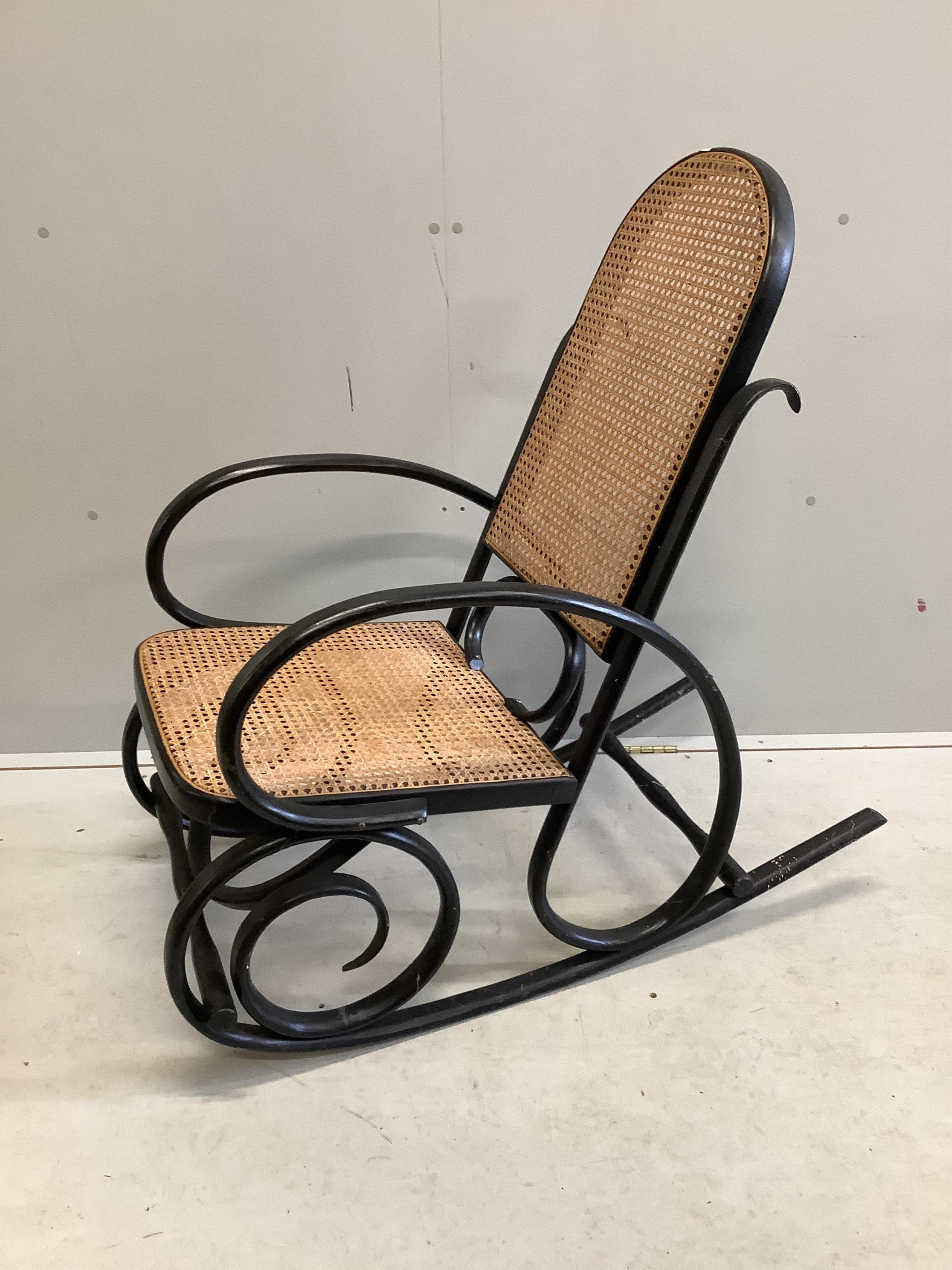 An early 20th century ebonised caned bentwood rocking chair, possibly Thonet, width 53cm, depth 100cm, height 100cm. Condition - fair to good